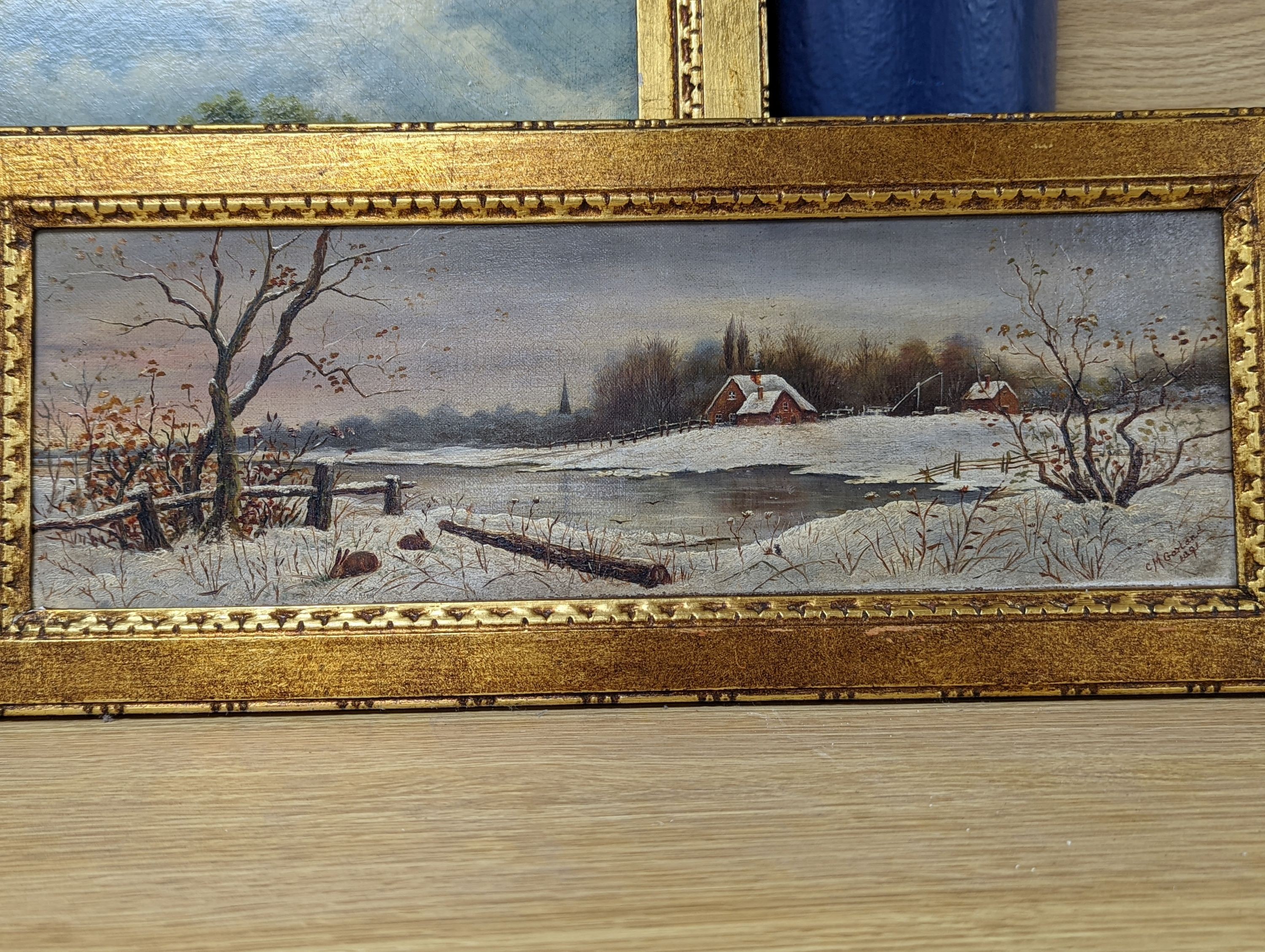 C. M. Garland, pair of oils on canvas, Summer and Winter landscapes, signed and dated 1891, 13 x 42cm and an oil of figures beside a pond, 1892, 27 x 37cm